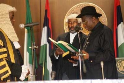 President Goodluck Jonathan, led by Chief Justice Katsina Alu, takes the oath of office.