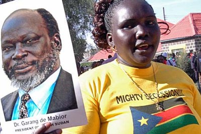une femme montrant un poster de John Garang
