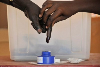 A man has his finger dipped in indelible ink after voting.
