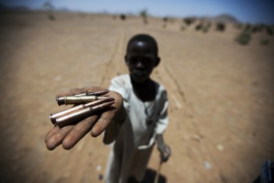 A child holds up bullets collected from the ground in Rounyn, a village about 15 kilometres from Shangel Tubaya, North Darfur (file photo).