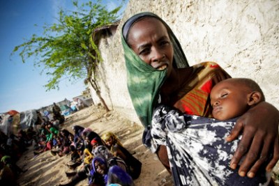 A Somali woman holds a malnourished child, waiting for medical assistance from the African Union Mission in Somalia.