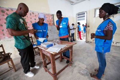 Liberian polling staff prepare ballots before inviting citizens into a polling station to vote in their countrys constitutional referendum, in Monrovia.