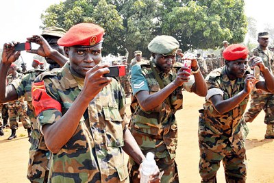Ugandan soldiers capture scenes with their cellphones after completing training for deployment to Somalia.