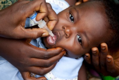 Child receiving oral polio vaccine.