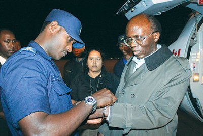 Léon Mugesera being handcuffed (file photo): Mugesera, a linguist and former politician, is accused of incitement to genocide in a 1992 speech. He was extradited from Canada after a 15-year battle against extradition.