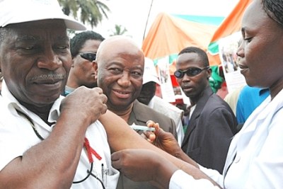 Liberian Health Minister Dr Walter Gwenigale receives a yellow fever vaccination.