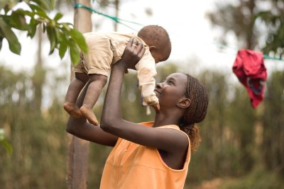 A mother plays with her young son in the Kenyan village of Mwea.