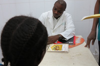 A medical worker at a clinic counsels a patient on family planning.