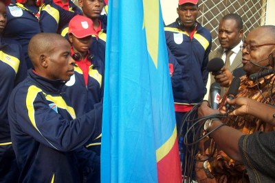 Le ministre des Sports, Baudoin Banza Mukalayi  remet le drapeau au porte-étendard de la délégation congolaise aux Jeux olympiques de Londres 2012