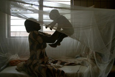 A woman and her baby under a mosquito net in Togo.