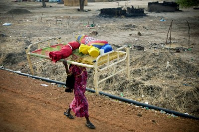 A woman carries a bed and other looted items through the streets of Abyei after clashes over the disputed area (file photo).