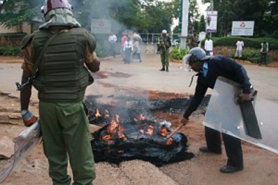 Anti-riot police put out a fire after rowdy youths in Kisumu engaged the police in running battles in protest against demolition of their structures (file photo).
