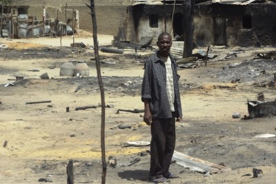 A man stands outside his destroyed home in Baga, Borno State (file photo).