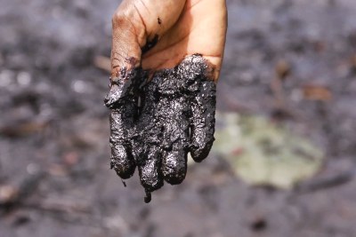 Pastor Christian Lekoya Kpandei's hand covered in oily mud, Bodo Creek (file photo).