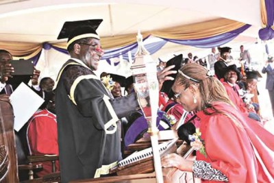 President Mugabe caps his wife Grace during  graduation.