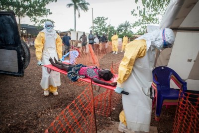 Medical staff bring in a weak patient who had been in contact with people infected with Ebola (file photo).