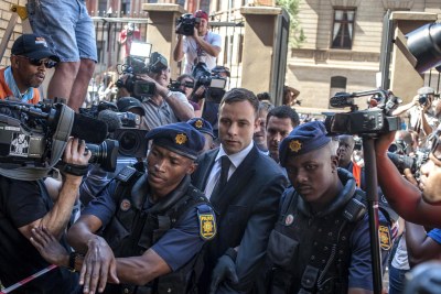 Paralympic athlete Oscar Pistorius escorted by police at the Pretoria High Court.