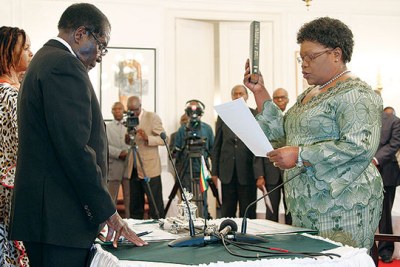 Former allies: President Robert Mugabe and former vice president Joice Mujuru during her swearing-in ceremony (file photo).