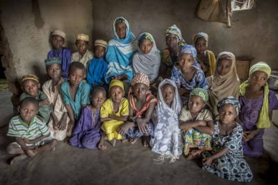 Bouba Mairama entourée d'enfants, parmi lesquels des réfugiés originaires de République centrafricaine dont elle s'occupe chez elle à Gbiti, au Cameroun.