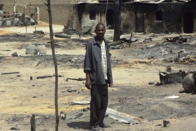 A man stands outside his destroyed home in Baga, Borno State (file photo).