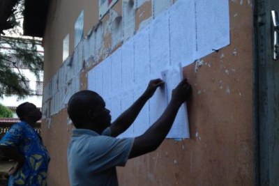 Les électeurs cherchent leur nom sur la liste affichée près de chaque bureau de vote pour les élections législatives, Cotonou le 26 avril 2016.