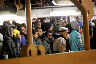 Rescued migrants and asylum seekers wait to leave an Italian Coastguard vessel in Palermo, Italy in April 2015.