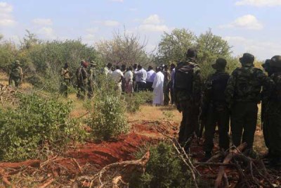 Police officers at one of the mass graves yesterday at Lathe Village in Mandera County. Twelve bodies were exhumed.