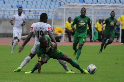 Young Africans striker Amis Tambwe fights his way past Mgambo JKT defender Salum Kipaga during their Premier League duel.