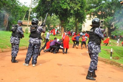 Makerere University students take cover as police fires bullets to disperse them during a strike.