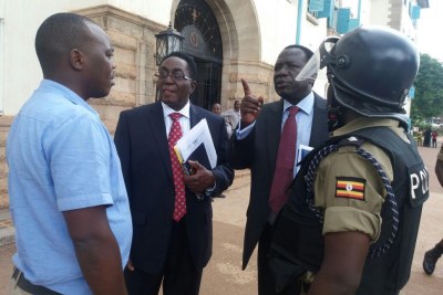 The Vice Chancellor Professor John Ddumba Ssentamu and the Council Chairman Eng.Dr.Charles Wanna Etyem with a police officer after the emergency council meeting.