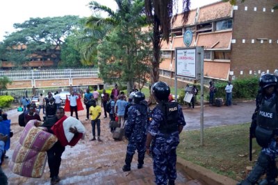 Riot police officers keep watch as students vacate Lumumba Hall.