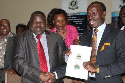 Knut chairman Mudzo Nzili (left) and Secretary-General Wilson Sossion display collective bargaining agreement that was signed between the union and the Teachers Service Commission (TSC) on October 25, 2016.