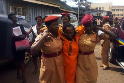 Stella Nyanzi arrives at court supported by prison warders. She told court she was not feeling well.