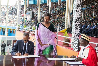 President Kagame signs documents sealing his re-inauguration as Head of State, shortly after he was sworn in by Chief Justice Sam Rugege (right). Looking on, centre, is First Lady Jeannette Kagame (file photo).