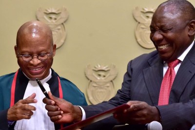 President Cyril Ramaphosa hands a pen to Chief Justice Mogoeng Mogoeng after being sworn in at a ceremony in Cape Town Thursday.