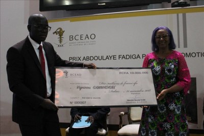 Le Togolais Vigninou GAMMADIGBE, lauréat du Prix Abdoulaye Fadiga pour la Promotion de la recherche économique 2018, recevant son chèque des mains de Mme Marie Elisabeth Viviane Zunon Kippre, première femme cadre a la BCEAO.