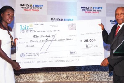 Former Botswanan president Festus Mogae (right) presents the $25,000 prize to Stacy Owino, the team leader of the Kenyan schoolgirls who won the Daily Trust African of the Year award (2018).