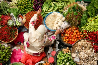 Une femme entrain de vendre des légumes