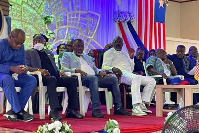 Liberia's Finance Minister Samuel Tweh, far left, Foreign Minister Dee-Maxwell Kemayah, and Chief of Staff Nathaniel McGill sit next to President George Weah during his tour of Montserrado County moments after the release of the US corruption report.