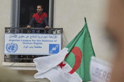 Un homme, debout sur un balcon des locaux de la Ligue algérienne pour la défense des droits de l’homme (LADDH), observait une manifestation à Alger, le 30 mars 2021.